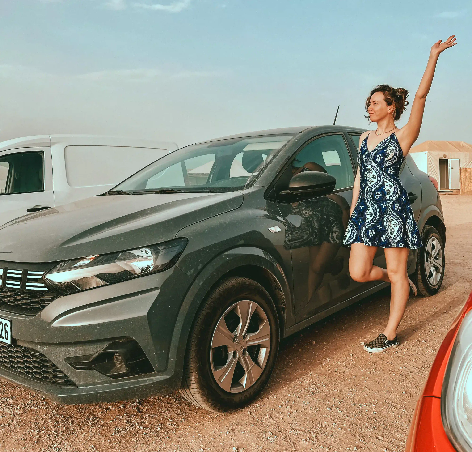 Girl standing next to a Dacia Sandero rental car in Morocco