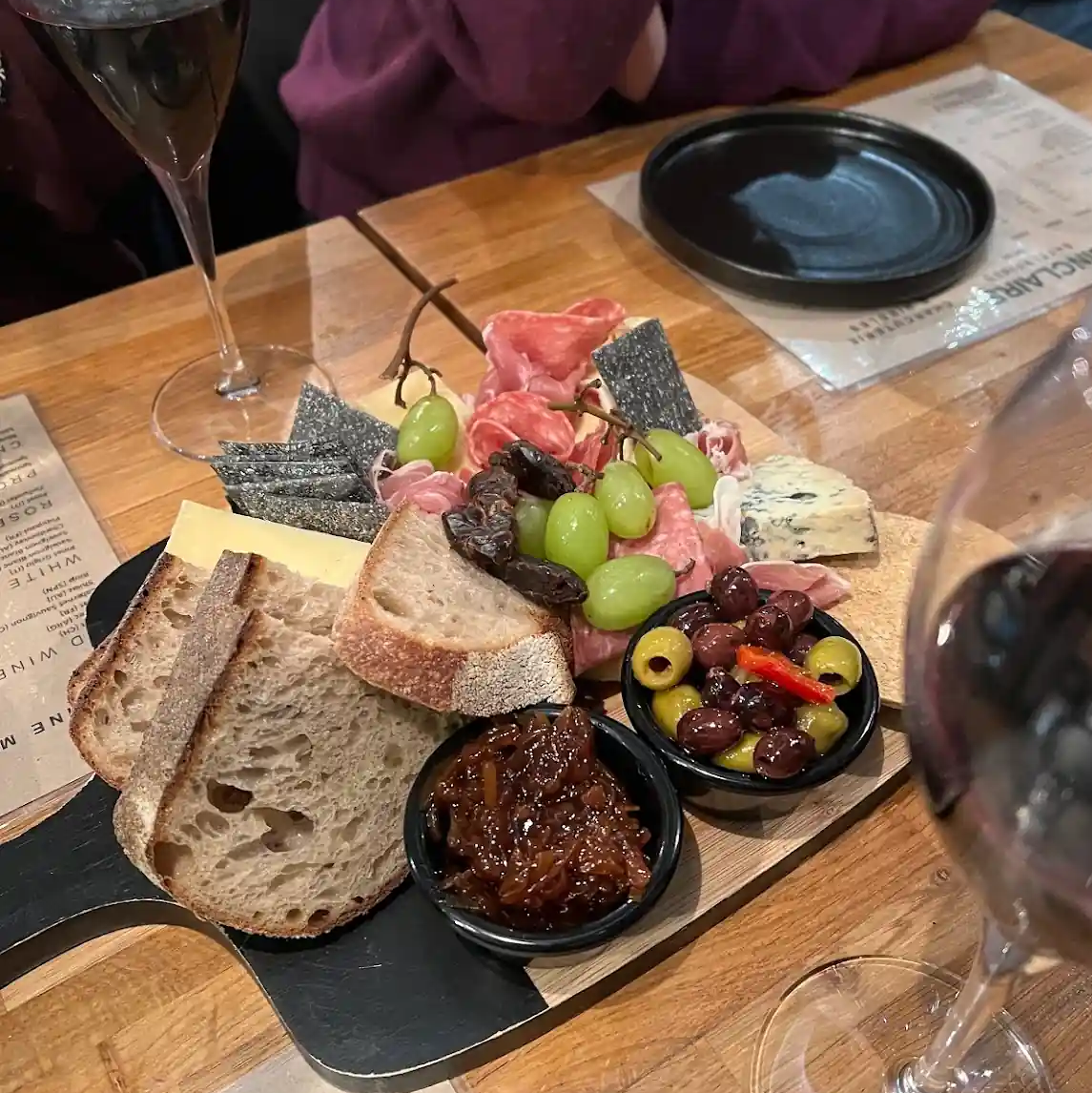 Charcuterie board and glasses of red wine.