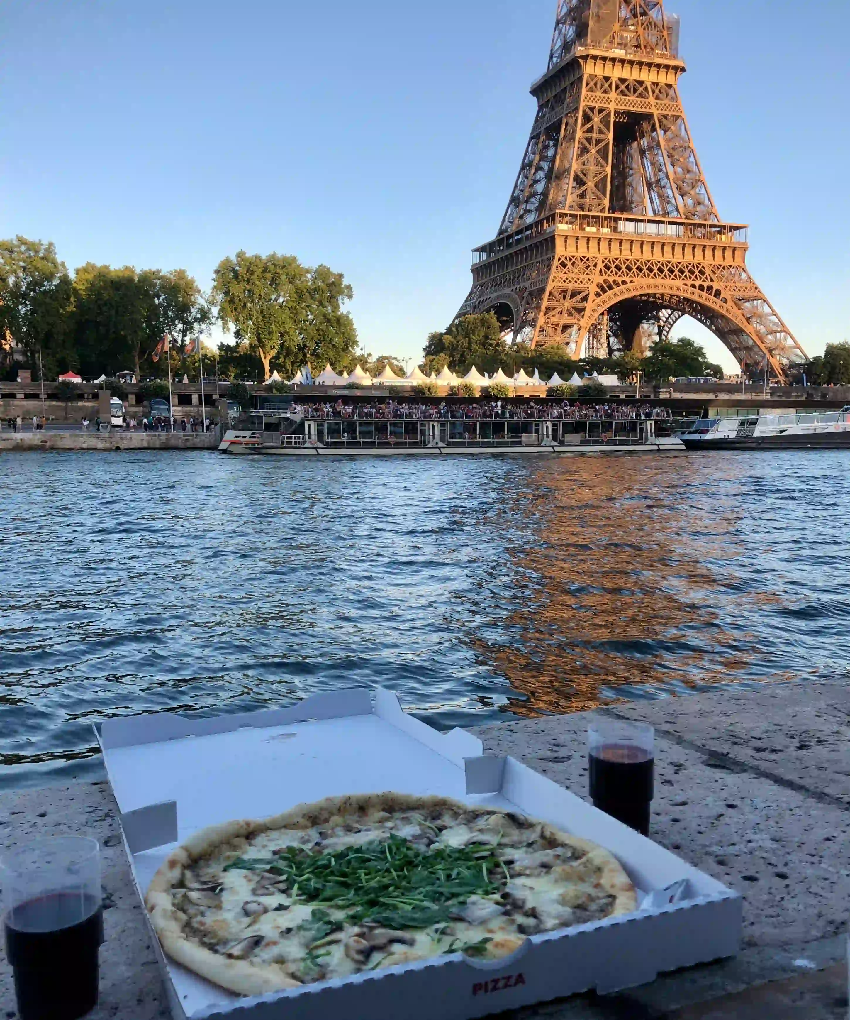 Takeaway pizza sitting by the River Seine in Paris, France.