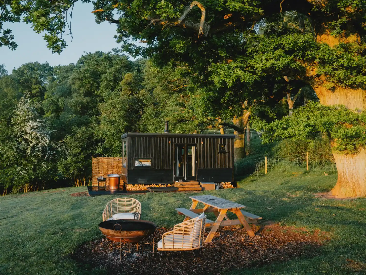 Rest + Wild Lodge Exterior with hot tub, picnic bench, and fire pit.