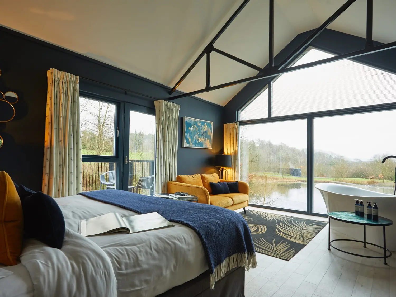 Boathouse Interior featuring bed and soaking tub with views over the lake at The Tawny Hotel.