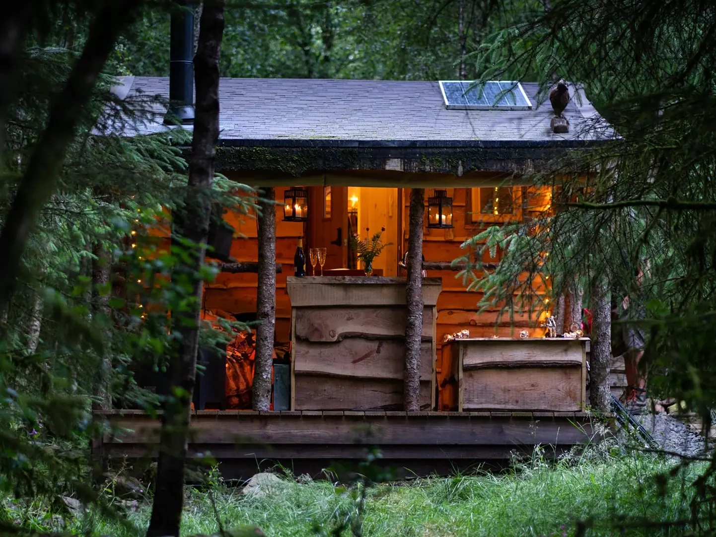 Outside of Badger’s Sett cabin surrounded by woodland at Dreamcatcher Cabins