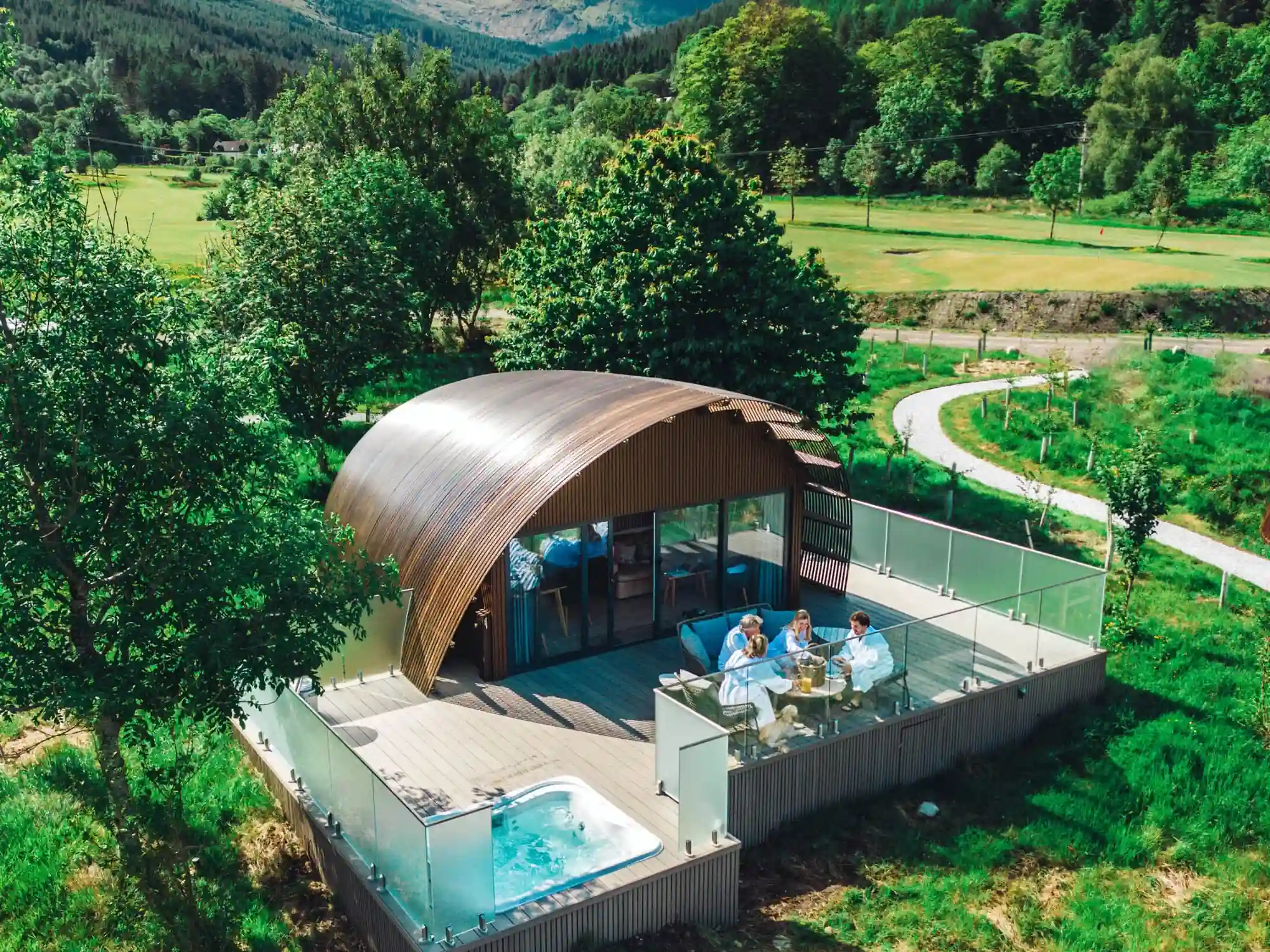 Aerial shot of Seabed Luxury Lodges at Woodlands Glencoe - picture shows hot tub, lodge and outdoor decking area.