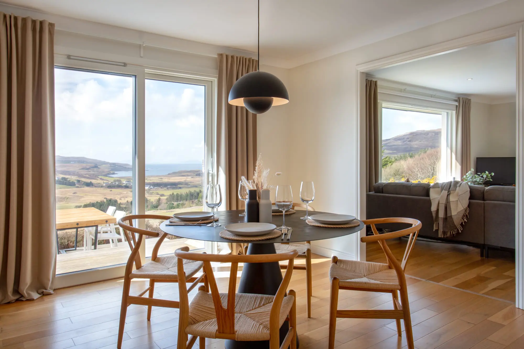 Dining table and living area with views of the outside scenery at the West Nest lodge.