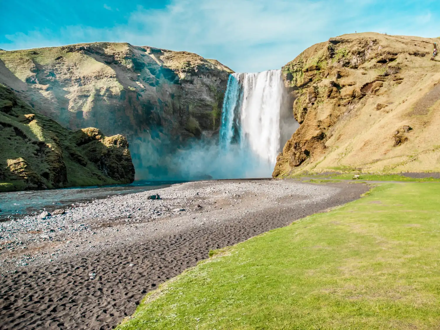 View of Skógarfoss Waterfall and surrounding hills, Iceland.