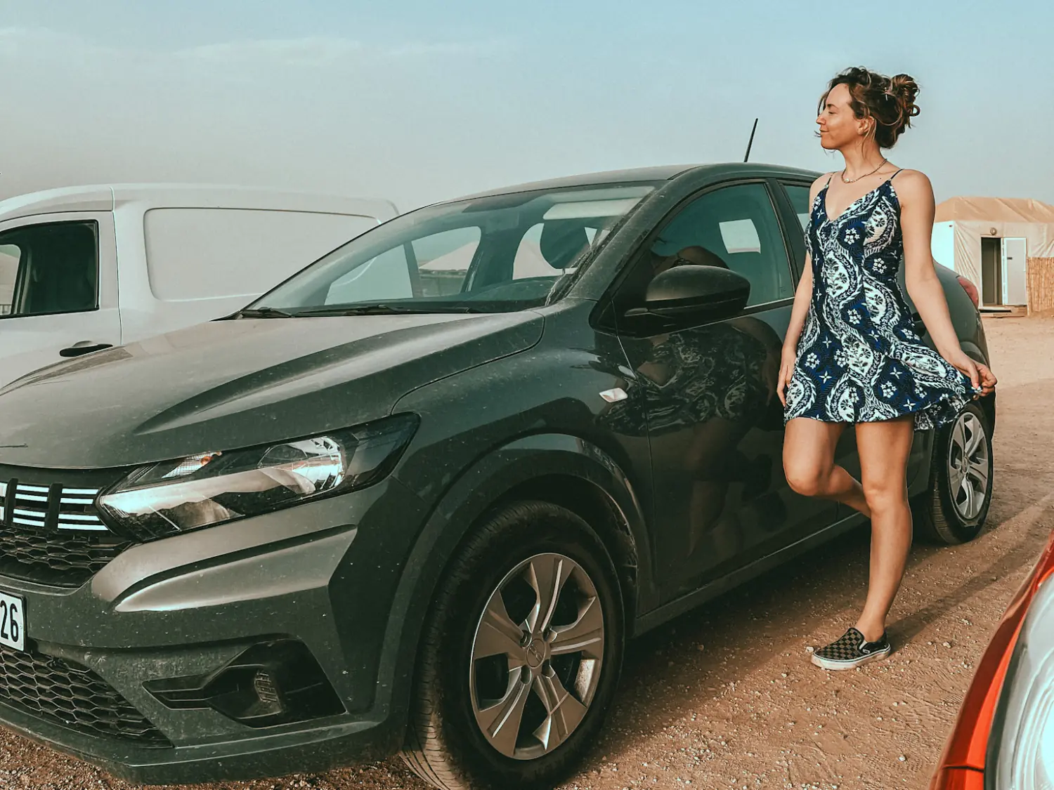 Girl standing in front of her rental car in Agafay Desert Morocco.