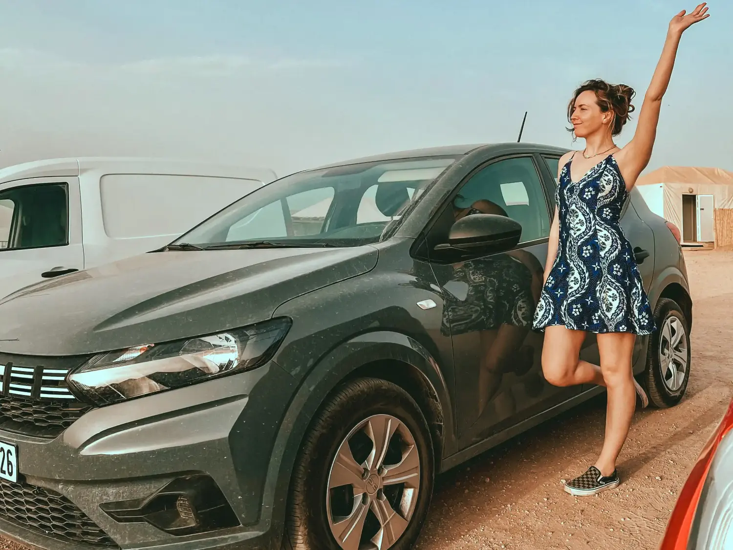 Girl standing next to a Dacia Sandero rental car in Morocco