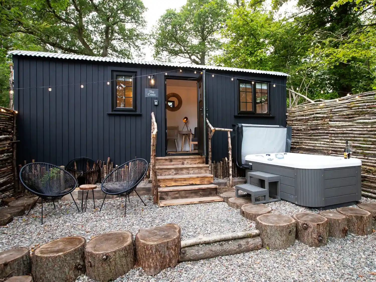 The exterior of The Conic Hut with hot tub and seating area at the Mar Huts.