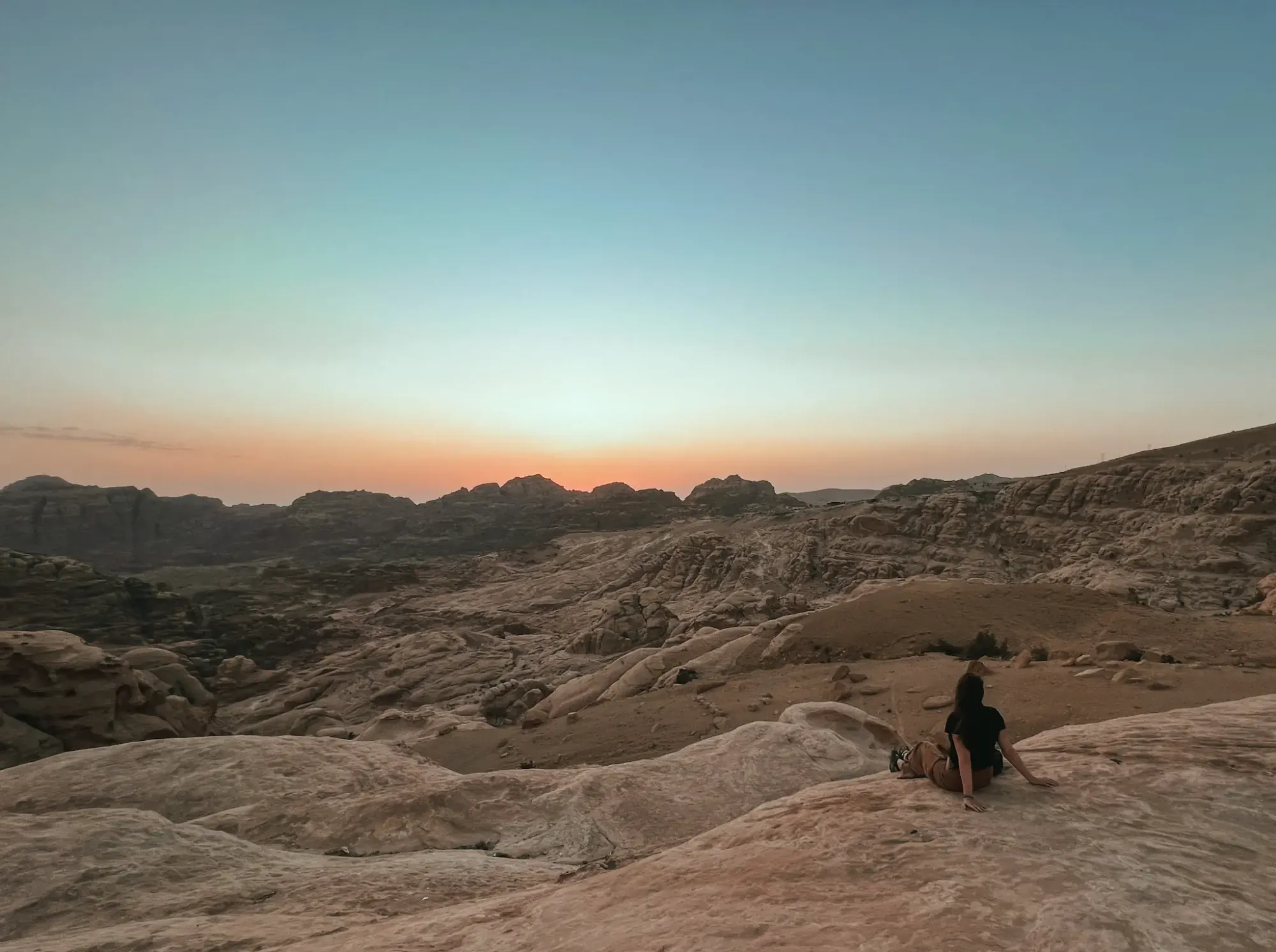 Girl watching the sunset at a viewpoint near Petra in Jordan.